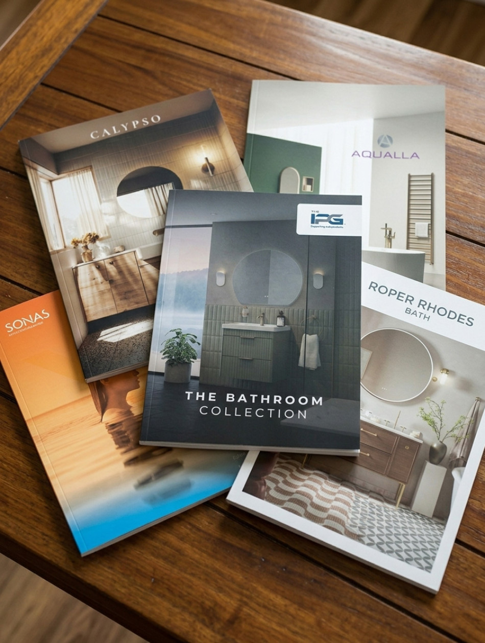 Several bathroom brochures laid out on a wooden table